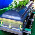 Beloved TV Star Gone at 75 A silver casket adorned with flowers at a gravesite