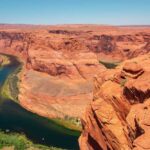 Colorado River winding through a red rock canyon under a clear blue sky