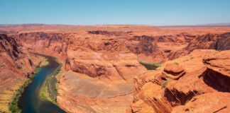 Colorado River winding through a red rock canyon under a clear blue sky