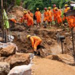 VIDEO: Garbage Buries Families – 30 Dead Rescue workers in orange uniforms search a landslide site with a dog