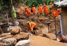 VIDEO: Wall Of Mud Kills Hundreds Rescue workers in orange uniforms search a landslide site with a dog