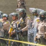 Teen Chaos Triggers 9 p.m. Clampdown Dontrelle Inman and Danny White among sheriff deputies in riot gear holding shields