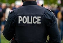 DA Drops Bomb: Cop Charged In Killing Back view of a police officer wearing a uniform with 'POLICE' displayed
