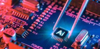 AI microchip on a blue circuit board held by tweezers