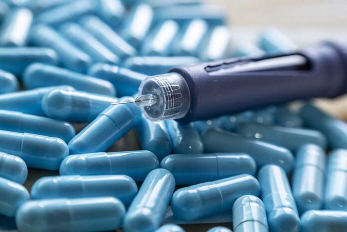 Insulin pen on blue capsules