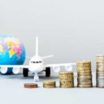 Holiday Flights STING – Prices Explode Stacked coins in front of a toy airplane and globe