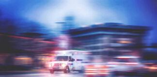 Ambulance speeding through city street at night