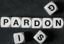 White letter blocks spelling 'PARDON' on a black surface