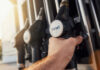 A hand holding a diesel fuel nozzle at a gas station