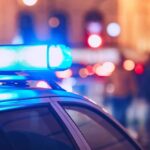 Baby Lost — Operator Nabbed Hours Later Close-up of a police car with blue emergency lights in a city at night