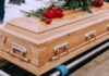 Wooden casket with red roses on top