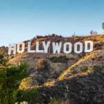 DOJ Greenlights Hollywood Giant – No Strings Hollywood Sign on a green hillside, sunny day.