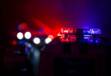 Soldier Ambushed Near White House Police car lights shining in the dark.