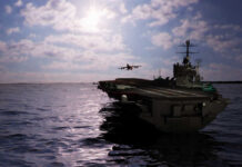 Three US Carriers Deployed Aircraft carrier at sea with jet approaching to land