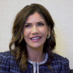 Kristi Noem Goes Public Gov Kristi Noem smiling indoors.