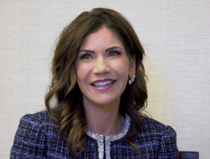 shutterstock_1962517687 Gov Kristi Noem smiling indoors.