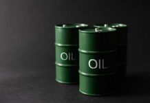 Trump Teases Offshore Oil Bonanza Green oil barrels on a dark background