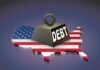 A heavy weight labeled 'DEBT' sits on a map of the United States, symbolizing economic challenges.