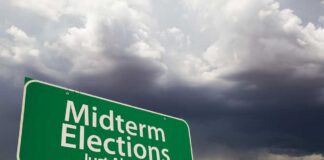 green roadside sign against a stormy sky