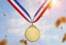 Trump’s Surprise Medal Move Stuns Silicon Valley Gold medal with blue, white, red ribbon, sky background.