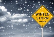 DEADLY SNOWSTORM – Bodies Found Days Later A yellow warning sign indicating a winter storm amidst falling snow