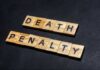 Governor Pulls Plug On Execution Wooden letter tiles spelling DEATH PENALTY on a dark background
