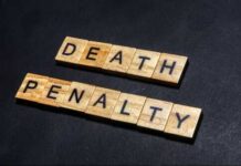 Governor Pulls Plug On Execution Wooden letter tiles spelling DEATH PENALTY on a dark background