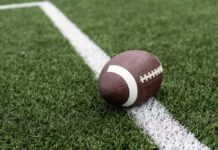 Deadly Wave Rattles NFL American football resting on a white yard line on a turf field