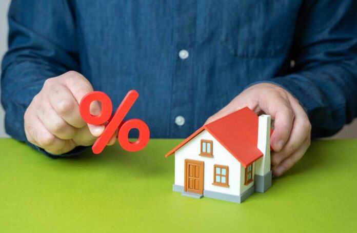 High,Mortgage,Rates,,Refinancing,Solutions,,Debt,Pressure,,Financial,Burden,,Housing Person holding a percentage symbol above a model house