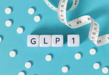 GLP-1 cubes with pills and a measuring tape on blue background