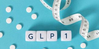 GLP-1 cubes with pills and a measuring tape on blue background