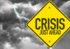 CEO PANIC Over Vanishing Trades Yellow sign reading Crisis Just Ahead with stormy sky