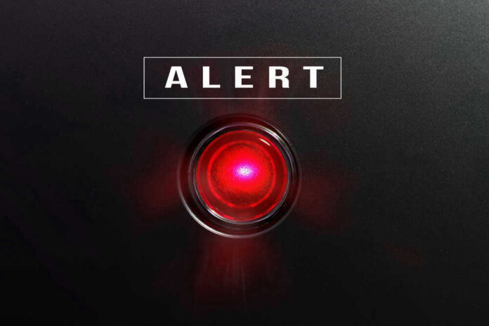 Red alert light against black background, text ALERT.