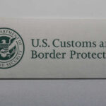 Border Patrol officer on boat watching another boat.