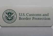 Border Patrol officer on boat watching another boat.